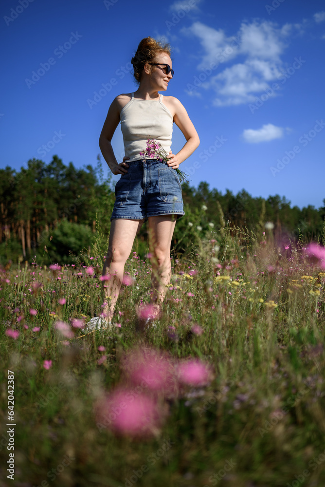 Redheaded woman in a field with wildflowers
