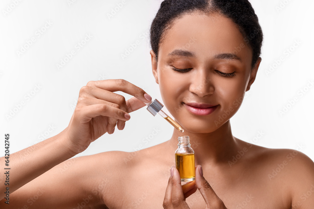 Fototapeta premium Beautiful woman with bottle of serum and dropper on white background