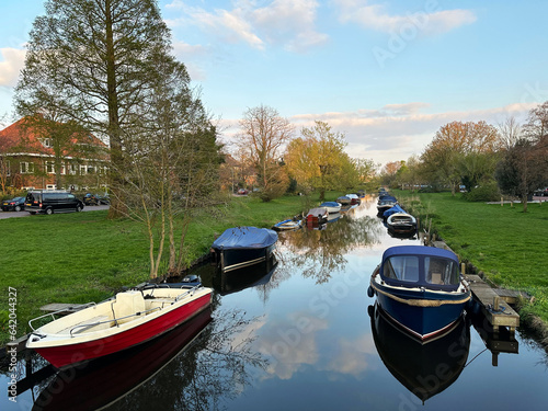 Beautiful view of canal with moored boats under blue sky photo