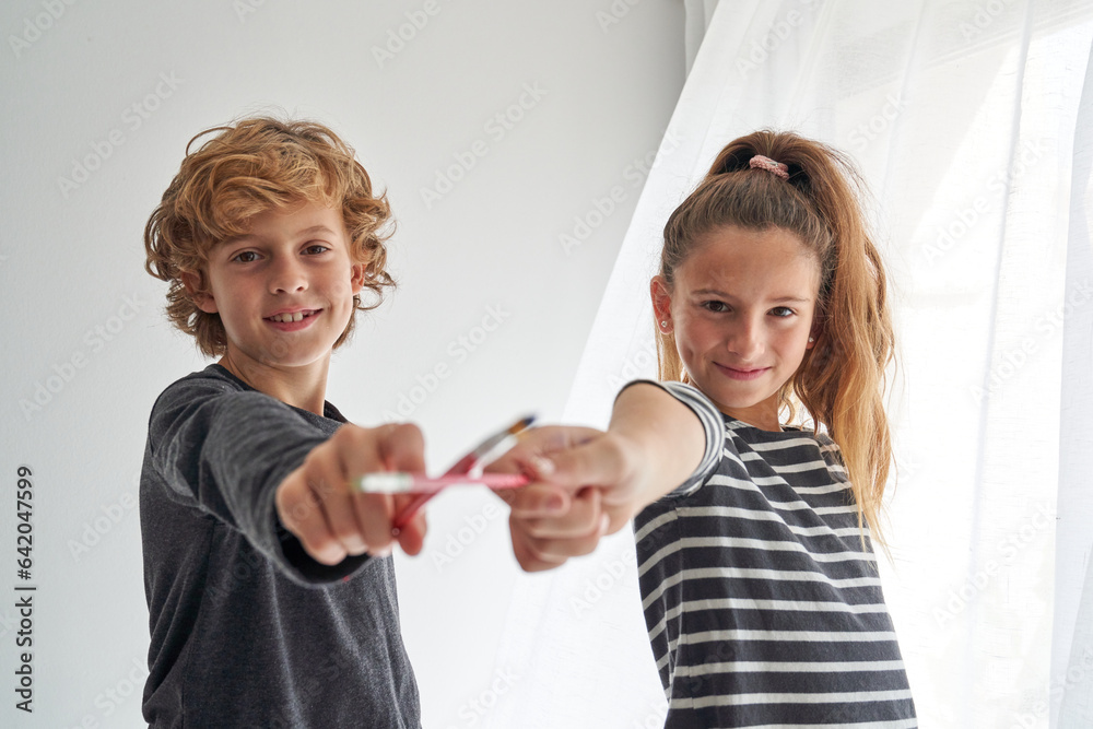 Cheerful children with paintbrushes in room Cheerful children with paintbrushes in room