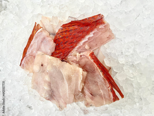 fresh raw cold seafood seven star whole fish ikan head, fillet, meat, cut, tail on white ice background halal food cuisine hyper market menu for restaurant ingredient design photo