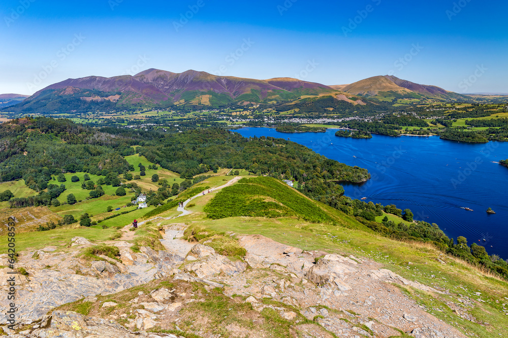 Hikers ascending a ridge overlooking a large lake (Catbells and Keswick, Cumbria)