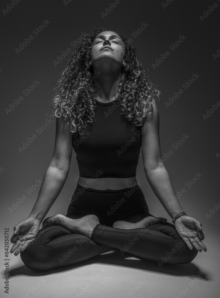 girl with curly hair sitting on floor making yoga girl with curly hair sitting on floor making yoga