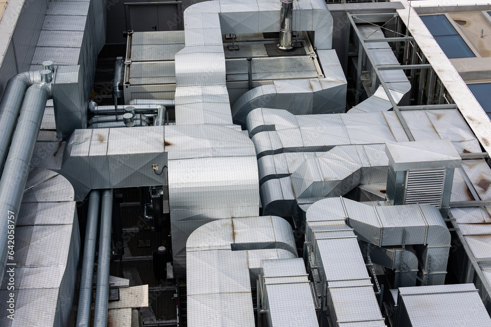 Ducts of the ventilation and air conditioning system on the roof of the building. The photo was taken in natural, soft light. View from above.