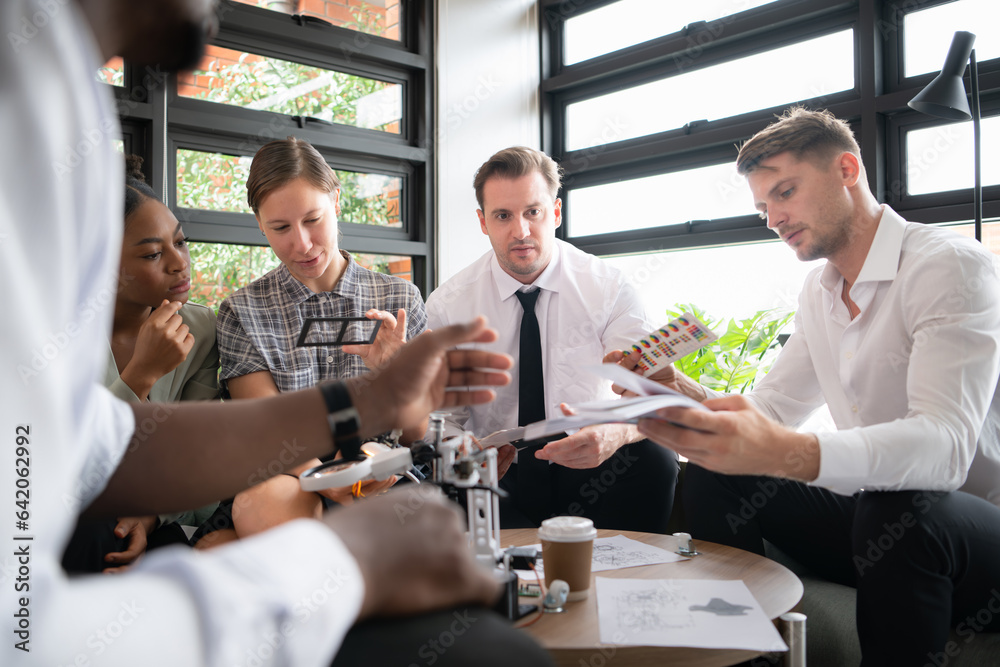 Group of diverse business people working together in the office, Brainstorming about the hand robot model to be used for production work Group of diverse business people working together in the office, Brainstorming about the hand robot model to be used for production work