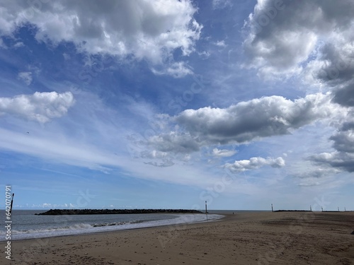 Landscape view of the beautiful sandy beach ocean shore at Sea Palling Norfolk UK with blue sky and white clouds on a hot bright sunny Summer day tranquil no people on holiday walking photo