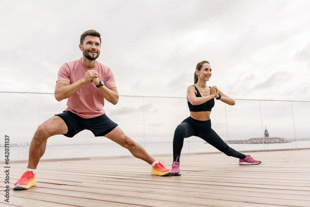People using smart watches for fitness, sportswear and running shoes.  Friends engaged in fitness running who train together.  Athletes pair full-length training.