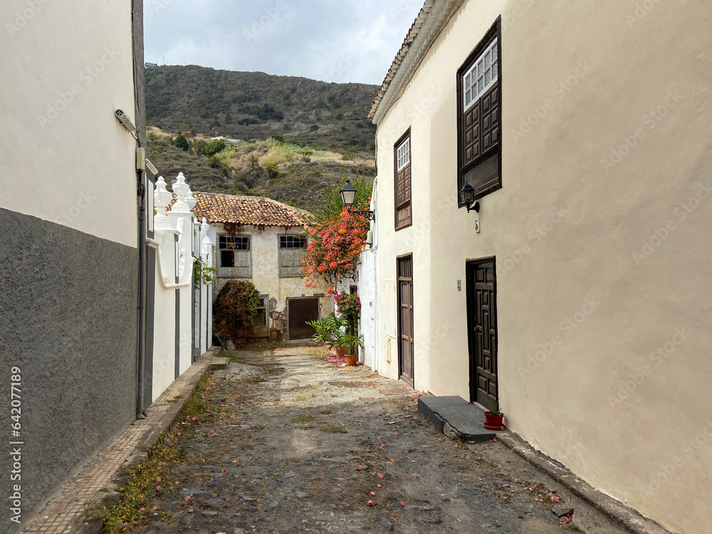 Cozy old street in Icod de Los Vinos, Tenerife, Canary Islands, Spain, canarian style rustic houses on the mountain background 