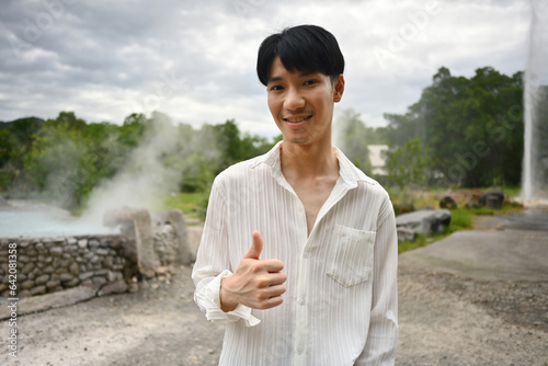 Portrait of a young Asian man giving a thumbs up. Recommended hot spring attractions