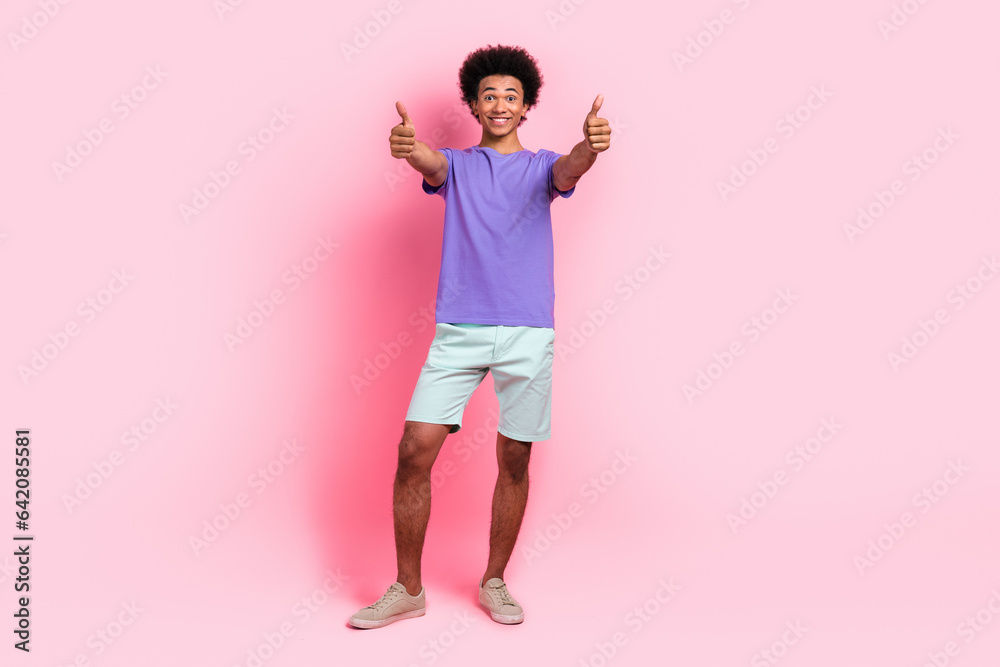 Full length photo of impressed man with afro hairstyle dressed blue t-shirt showing thumbs up good work isolated on pink color background Full length photo of impressed man with afro hairstyle dressed blue t-shirt showing thumbs up good work isolated on pink color background