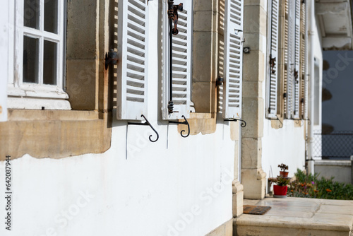 Des vieux volets blanc accroché à une vielle maison de maître en France en compagne photo