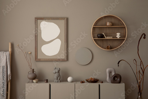 Interior design of cozy living room with mock up poster frame  brown sideboard  vase with dried flowers  round shelf on wall  sculpture and personal accessories. Home decor. Template.