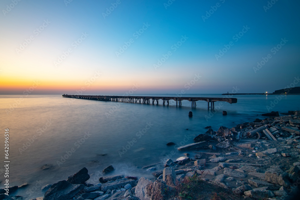 Obraz premium long exposure of old and abandoned pier. Beautiful sunset and light in Filyos beach of in Zonguldak 