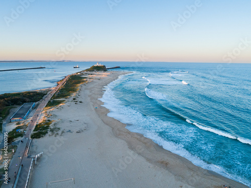Nobbys beach at sunset with tide coming in seen from aerial perspective