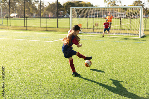 girl playing soccer and kicking a goal photo
