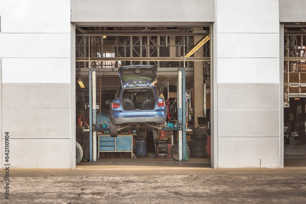 Automotive Maintenance Car on Lifting Platform in Garage for Repairs