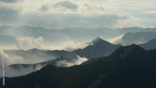 tme-lapse, of mountains top view with flowing/flying clouds and fogs in the morning sunrise. photo