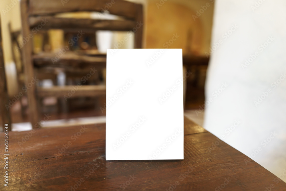 Menu mock up blank for text marketing promotion. Mock up Menu frame standing on wood table in restaurant space for text Menu mock up blank for text marketing promotion. Mock up Menu frame standing on wood table in restaurant space for text