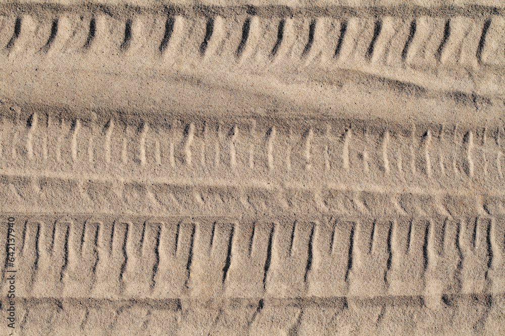 Footprint of a car wheel in the sand close-up