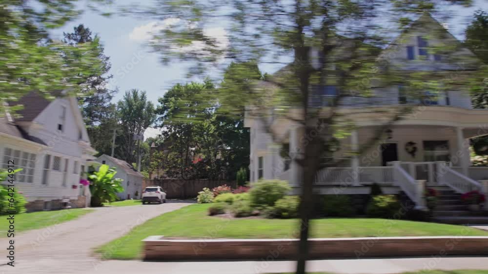 Driving shot and car passenger point-of-view POV out of window at sidewalks, old homes, colonial buildings, and neighborhood in Granville, Ohio during a nostalgic warm summer day Driving shot and car passenger point-of-view POV out of window at sidewalks, old homes, colonial buildings, and neighborhood in Granville, Ohio during a nostalgic warm summer day