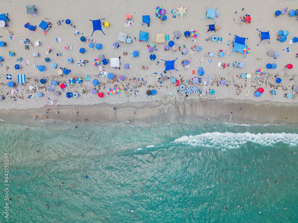 Aerial top-down photo of a busy day at the beach with waves.