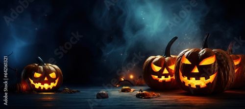 Jack O' Lantern halloween pumpkins on background of a scary halloween night. Copy space