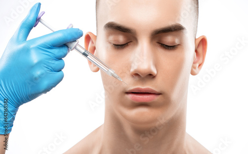 Men s cosmetology. Beautician makes a rejuvenation injection procedure on the face of a young man.