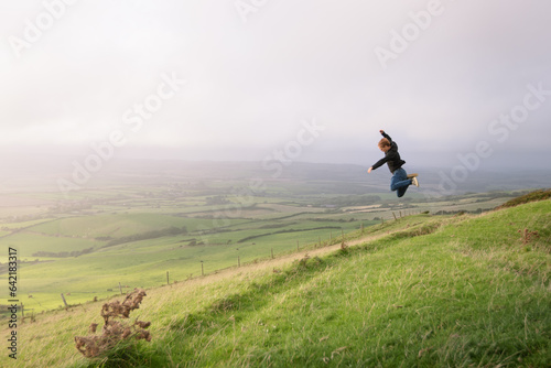 A man jumping on top of a mountain