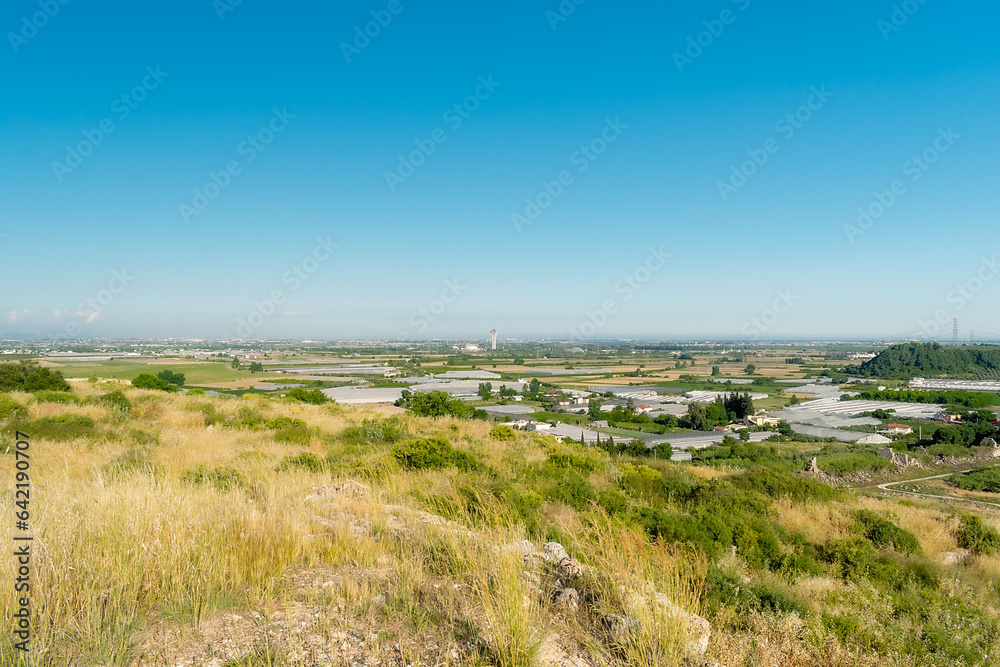 Panorama. Daytime landscape of the surroundings of the ancient city of Perge from a high point. Agricultural fields near the city of Perge in the province of Antalya, Türkiye. Panorama. Daytime landscape of the surroundings of the ancient city of Perge from a high point. Agricultural fields near the city of Perge in the province of Antalya, Türkiye.