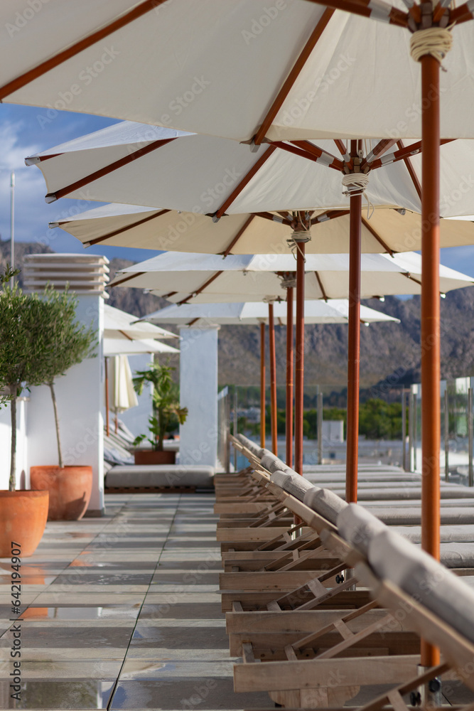Sun loungers near pool with umbrella parasol beautiful sunny day Sun loungers near pool with umbrella parasol beautiful sunny day