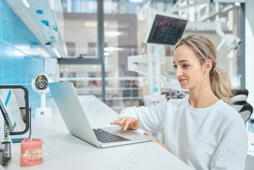 Young female working on laptop in the hospital