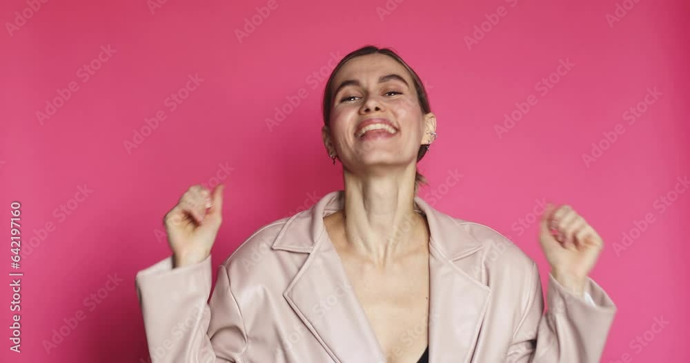 Smiling overjoyed beautiful brunette young woman in leather jacket posing doing winner gesture, say Yes isolated on pink background in studio. Wow woman emotion, surprised girl face. Smiling overjoyed beautiful brunette young woman in leather jacket posing doing winner gesture, say Yes isolated on pink background in studio. Wow woman emotion, surprised girl face.