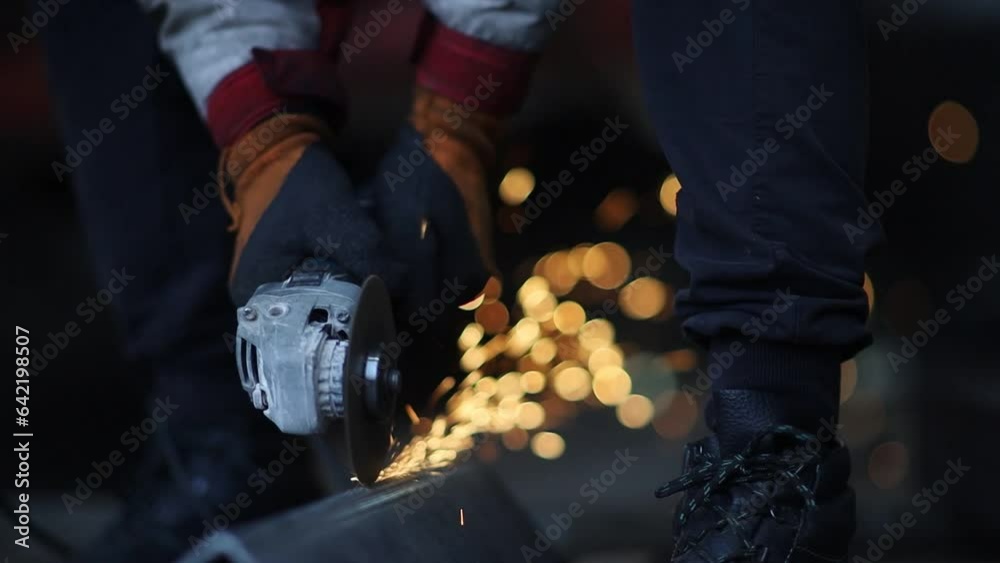 grinding and cutting metal in the production of a grinder close-up with flying sparks