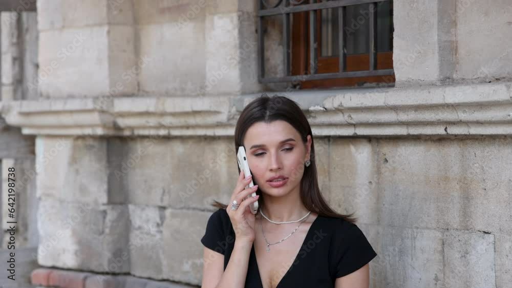 business woman in dress talking at smartphone, sitting in outdoor cafe with laptop, remote job freelance.beautiful girl outside,smiling happy female against building wall,drinking iced coffee 4k business woman in dress talking at smartphone, sitting in outdoor cafe with laptop, remote job freelance.beautiful girl outside,smiling happy female against building wall,drinking iced coffee 4k