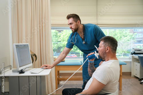 Pulmonologist monitoring patient lung function during spirometry test photo