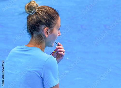 judge on water sports. The girl the sports judge with a roll in canoepolo. Water sports coach. woman with a whistle against the background water surface photo