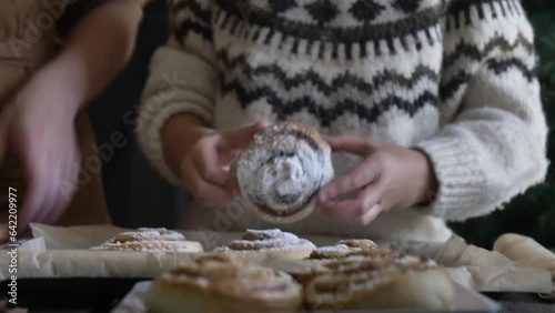 Mother and son eating baked Swedish Cinnamon Buns on table at home