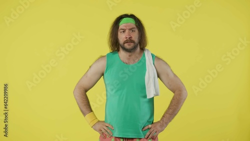 Man in green top and headband with white towel on the shoulder. Isolated on yellow background.