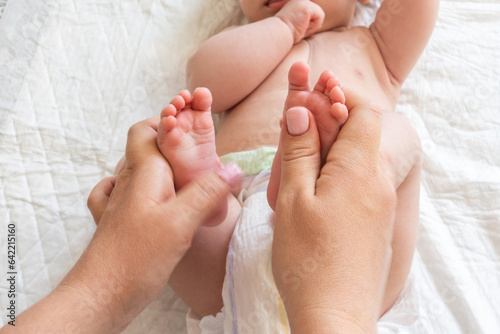 Focus on baby feet during a loving massage. Concept of moments of pure connection