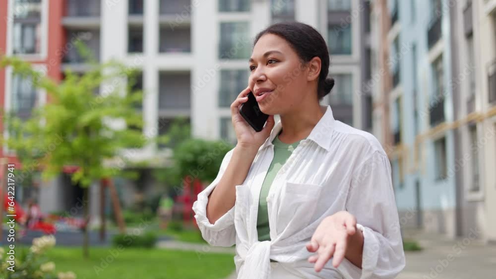 Beautiful Charming Business Woman Talking on Mobile Phone While Standing Outside Business Center and Explains Somethind while Waving Hands. Pretty Lady Having a Phone Conversation Outdoors Beautiful Charming Business Woman Talking on Mobile Phone While Standing Outside Business Center and Explains Somethind while Waving Hands. Pretty Lady Having a Phone Conversation Outdoors