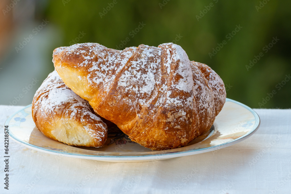 Italian sweet breakfast, fresh baked croissant buttery pastry with sugar powder