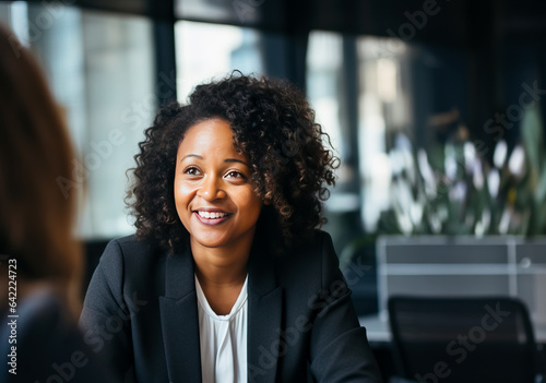 Woman in a suit at a job interview at an office, sitting across the table from HR and the manager. Concept of job searching, headhunters and career choices. Shallow field of view.