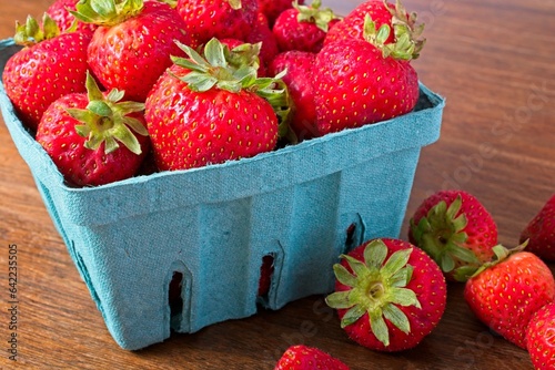Close up quart of strawberries on a rustic wooden table.
