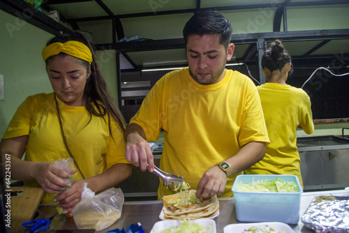 Equipo de cocina preparando pedidos de comida, Taquería mexicana
