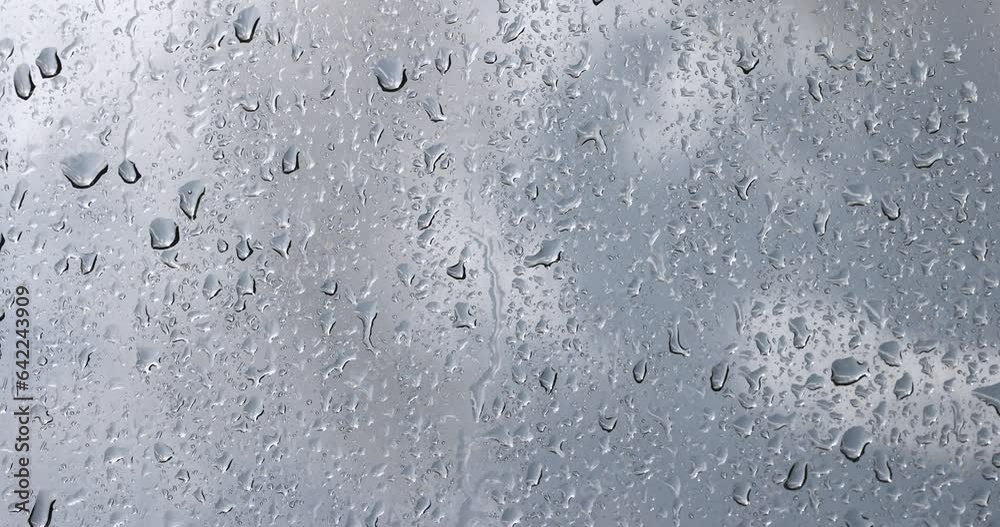glass with water drops during rain, glass covered with rain water drops in a building window glass with water drops during rain, glass covered with rain water drops in a building window