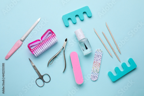 Set of pedicure tools on light blue background  flat lay