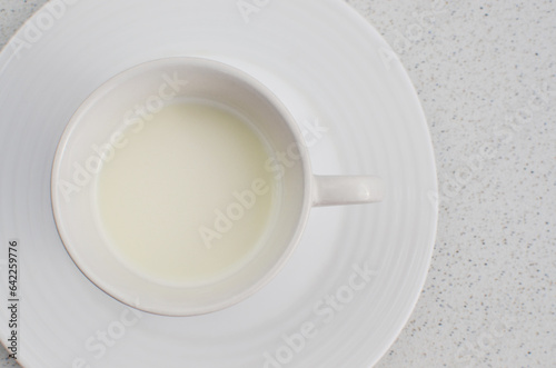 Close-up of the white cup with fresh milk, exuding freshness and readiness to be enjoyed at the table.