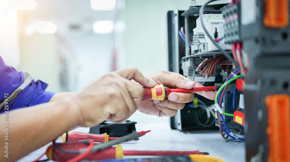 As an engineer fixes the automatic control switchboard to ensure safe ...