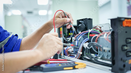 фотографія Electrical engineer checking and fixing automatic control switchboard to resume normal operation, industrial technology work concept and work safety