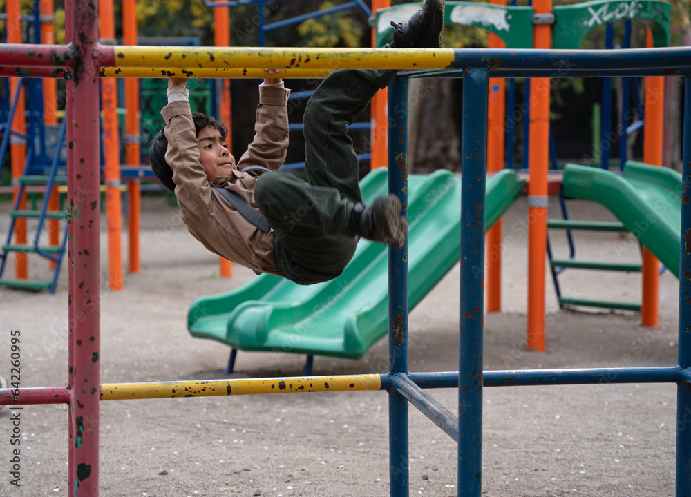 Fototapeta premium boy playing on playground equipment in a park